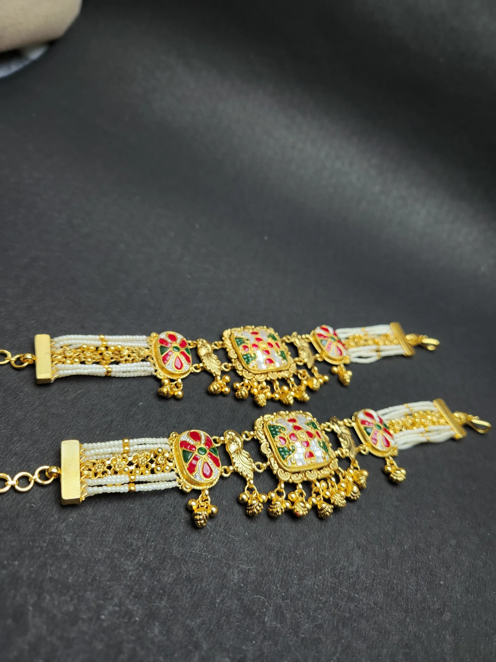 Pair of pearl-bead and gold bracelets with square kundan-style centres in white, red and green, and bead drops