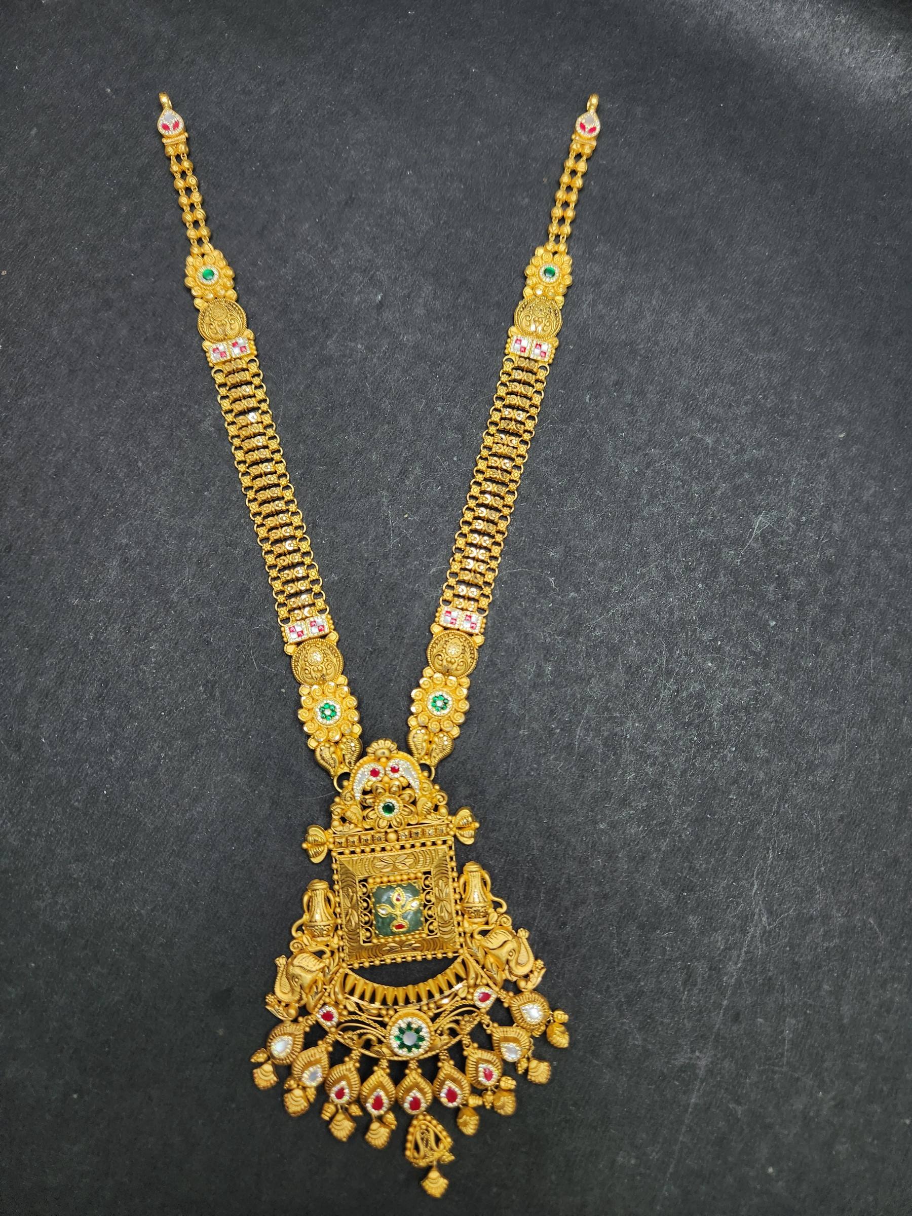 Long gold jaali haram with square pendant, green centre, pair of elephant motifs and red and white stones