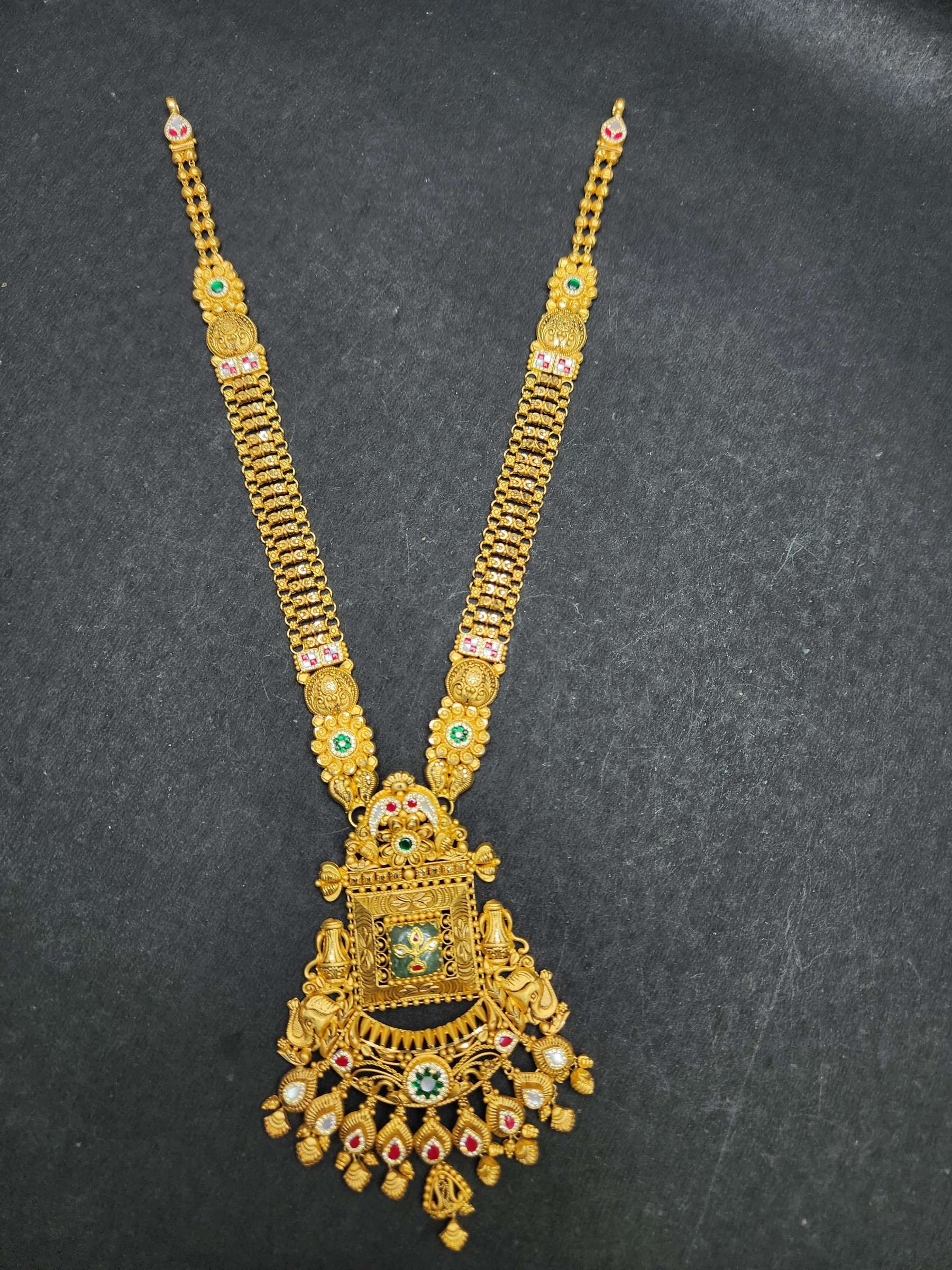 Close view of a gold jaali haram pendant with elephant motifs