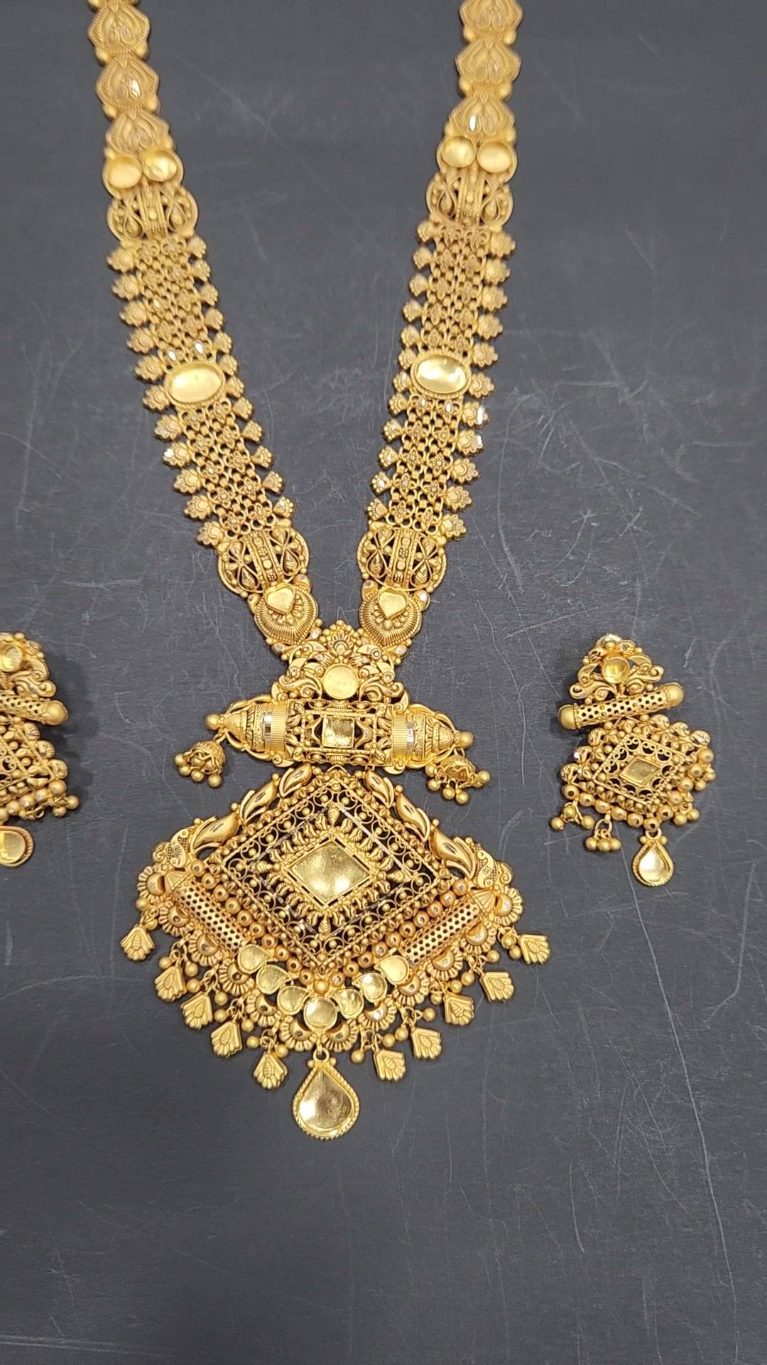 Long matte gold rani haar with jaali links, diamond-shaped filigree pendant and matching earrings