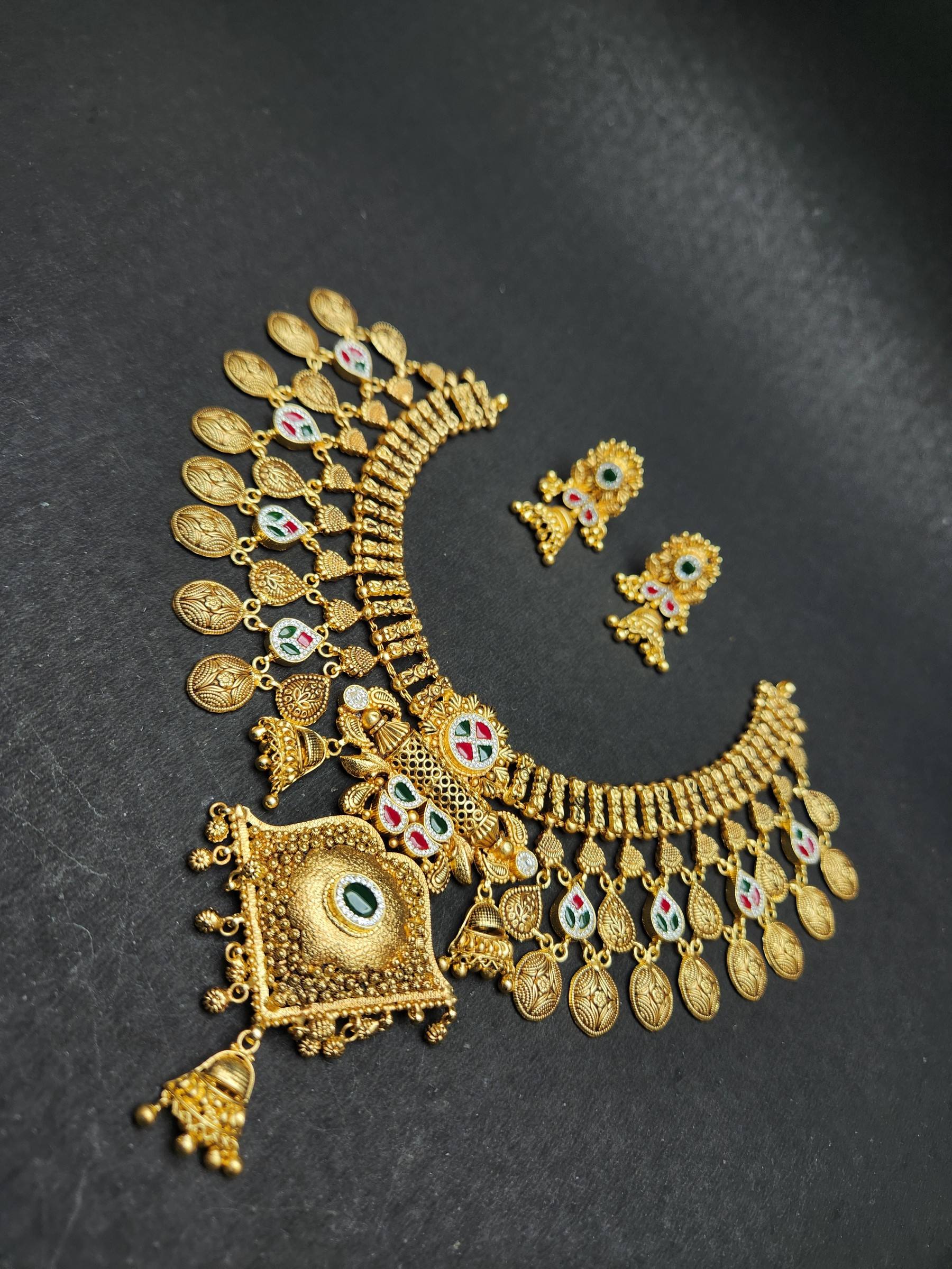 Gold collar necklace with engraved leaf fringe, pink and green stone drops, square pendant and matching jhumkas